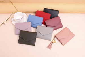 Variety of colorful faux leather tri-fold wallets with gold heart charms and tassel details