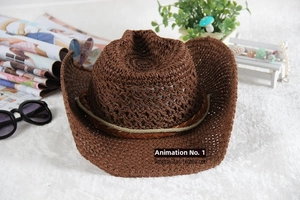 Detail of dark brown woven straw cowboy hat with decorative band on a textured surface