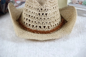 Close-up of hollow-out woven straw fibers and brown decorative band on a cowboy sun hat