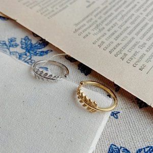 925 silver leaf open rings in gold and silver finish on a vintage book backdrop