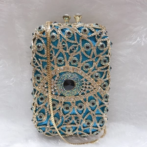 Detail der Luxus-Abendtasche mit blauem Glitzer, Gold-Metall und bösem Blick Kristallen