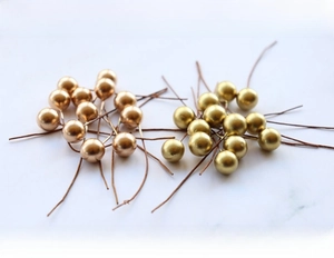 Detailed close-up of 10mm metallic gold and copper berries on stems for DIY crafts