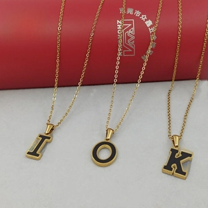 Vista detallada de collares de acero inoxidable dorado con letras de esmalte negro