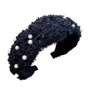 Detail of black tweed headband featuring delicate woven texture and white pearl accents