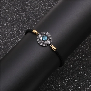 Adjustable black woven Evil Eye bracelet with gold hardware and sparkling zircon inlay