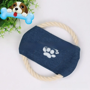 Detail of durable cotton rope dog frisbee with blue denim fabric and paw print embroidery