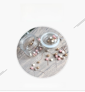 Close-up of 12mm mixed pink and gold foam berries with metal stems in a glass jar