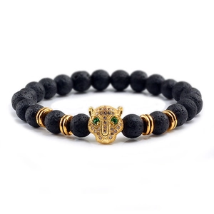 Detail of volcanic stone bracelet with golden leopard head and green zircon eyes