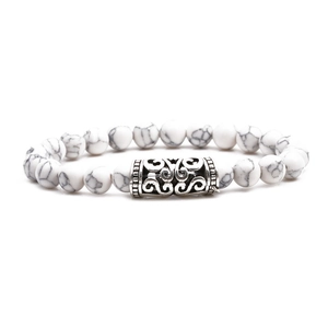 White marble bead bracelet with silver hollow carved charm on clean white background