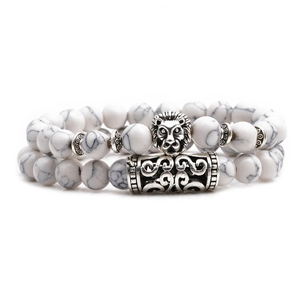 Close-up of white turquoise beaded bracelets with vintage silver lion head and totem charms