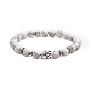 Detailed view of white turquoise beads and metallic Buddha head charm on the bracelet