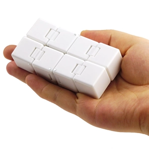 White plastic infinity cube stress relief toy held in hand on white background