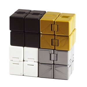 Stack of four Infinity Cubes in black, white, gold, and silver finishes for stress relief