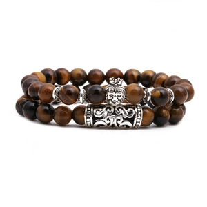 Detail view of tiger eye beaded bracelet set featuring silver crown lion head and vintage tube
