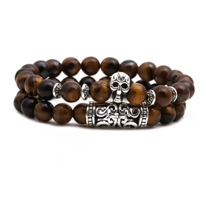 Macro view of tiger eye beads with vintage silver skull and carved metal spacers