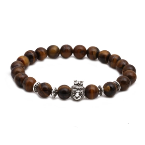 Macro view of tiger eye bead bracelet featuring a silver lion head charm with crown