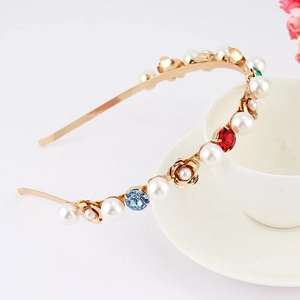 Detailed shot of gold metal headband with pearls and colorful gemstone flowers