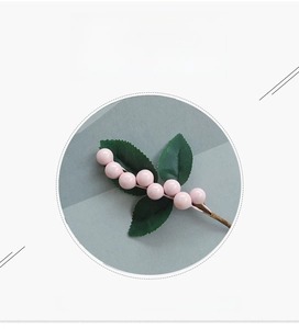 Detail of pink foam berries and green leaves on a handmade artificial decorative spray