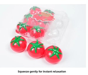 Detail view of red tomato splat relief toys in a clear box with loose items on white background