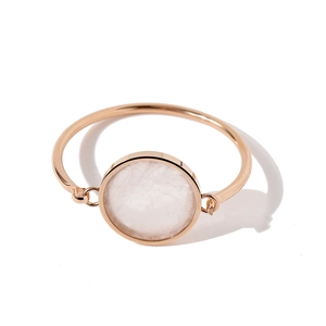 Detail of rose gold bangle featuring a round white natural stone with unique textures