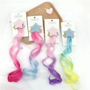 Close-up of glitter star hair clips with colorful rainbow gradient hair extensions for kids