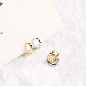Detailed macro view of S925 sterling silver stamp on gear-shaped hoop earrings