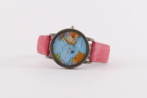 Detail of world map watch dial with bronze case and pink denim fabric strap
