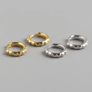 Detail of gear-shaped S925 silver hoop earrings with sparkling diamonds in gold and silver