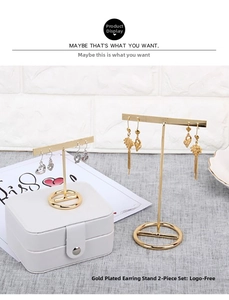 Detailed view of two gold-plated T-shaped earring stands in different heights
