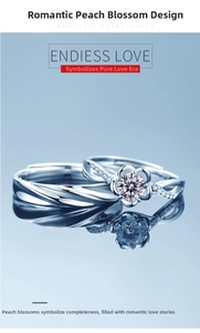 Close-up of silver couple rings featuring a peach blossom design and sparkling diamonds