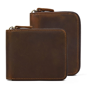 Detail view of two brown genuine leather wallets with zippers and visible grain texture
