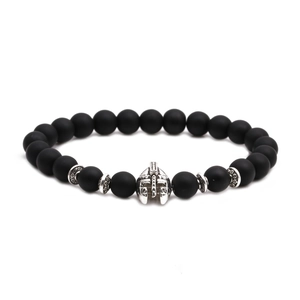 Detailed macro of matte black beads bracelet featuring a silver Spartan helmet charm