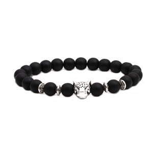 Close-up of matte black agate beaded bracelet featuring a silver leopard head charm