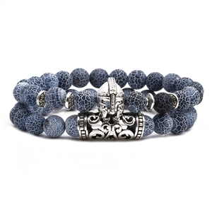 Detail of beaded bracelet featuring dark blue crackle beads and silver Spartan helmet charm