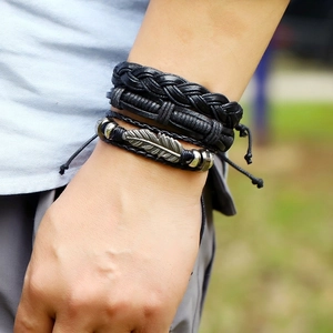 Handmade bohemian leather bracelet set with metallic feather pendant and vintage beads