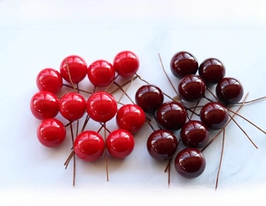 Dettaglio macro di bacche artificiali da 16mm rosse e viola con finitura lucida e stelo
