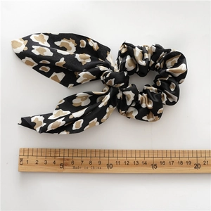 Leopard print satin scrunchie with rabbit ear bow on a white background with ruler