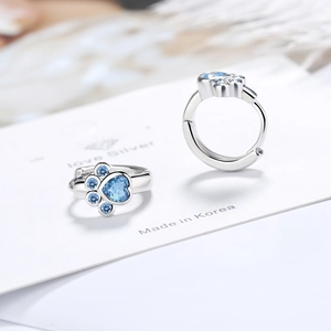 Silver cat paw earrings with heart-shaped blue zirconia stones in a hoop design