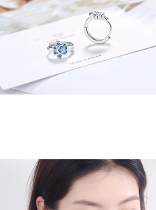Detail of silver cat paw hoop earrings featuring blue zircons with on-model view