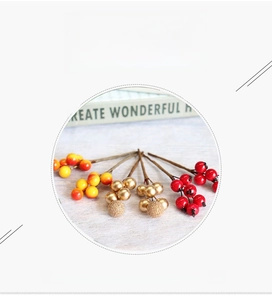 Close-up of decorative artificial red and gold berries for Christmas DIY floral crafts