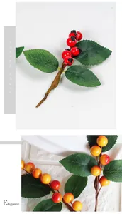 Close-up of decorative artificial red berry branches with detailed green leaves
