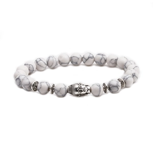 Detail of white turquoise beaded bracelet featuring a silver-colored Buddha head charm