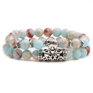 Close-up of bohemian beaded bracelet set featuring metal elephant and cylinder charms