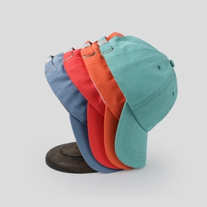 Detail view of cotton baseball caps in four colors featuring adjustable metal back buckles