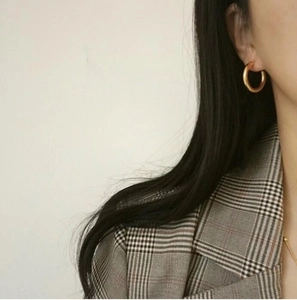 Classic golden hoop earrings shown on a model for size and style reference