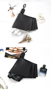 Detail view of foldable black umbrellas with classic black and white grid interior patterns