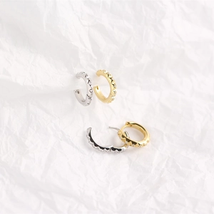 Macro detail of S925 sterling silver gear earrings with gold and silver crystal accents