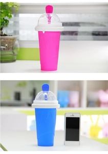 Detail view of pink and blue silicone slushy maker cups with spoon and dome lid accessories