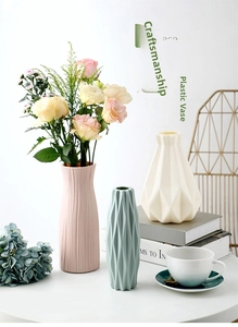 Vue détaillée de trois vases nordiques en plastique rose, cyan et blanc aux formes géométriques