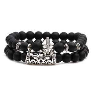 Matte black beaded bracelet set with silver Spartan helmet and engraved metal tube charms